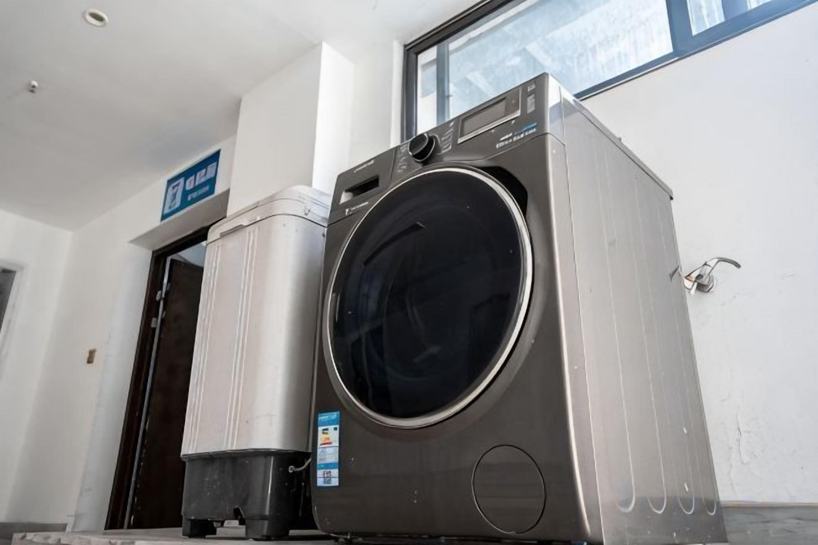 A front-loading washing machine in a room with a door and a window.