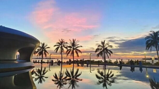 A reflective pool with palm trees and a sunset sky. - V8 Wisdom Hotel (Haikou CRV East Railway Station) (Haikou)