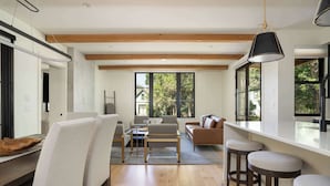 Um interior moderno com área de refeições, assentos e grandes janelas.