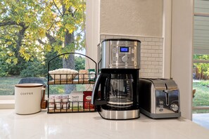 A kitchen counter with a coffee maker, toaster, and a coffee mug. - Denver 3bed/2 bath with spacious backyard (Arvada)