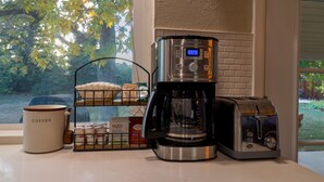 A coffee maker, toaster, and coffee mug on a kitchen counter with a window view. - Denver 3bed/2 bath with spacious backyard (Arvada)
