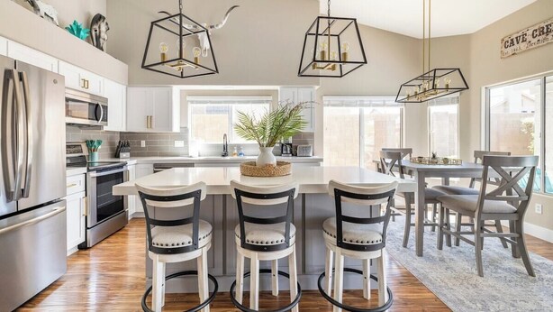 A modern kitchen with a central island, bar stools, and pendant lighting. - Cave Creek Gem: Heated Pool, Sleeps 8 (Cave Creek)