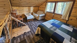 Une chambre confortable dans un chalet, avec un lit, un canapé, une table et une chaise.