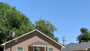 A single-story house with a front porch, a garage, and a small front yard.