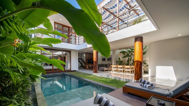 A modern house with a glass-bottomed pool, wooden deck, and lounge area with sun loungers. - Walking distance from Berawa Beach - 4 BDR (Kecamatan Kuta Selatan)