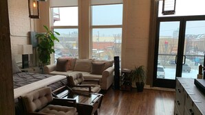 A spacious living room with a large sofa set, a coffee table, and a fireplace.