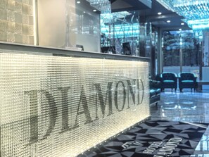 A lobby with a reflective wall and a geometric patterned floor. - Hotel DIAMOND (Tokyo)