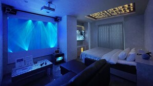 A hotel room with a bed, a desk, and a large screen displaying a hotel name. - Hotel DIAMOND (Tokyo)