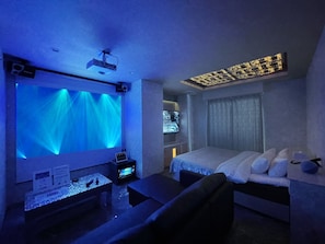 A hotel room with a bed, a desk, and a large screen displaying a hotel name. - Hotel DIAMOND (Tokyo)