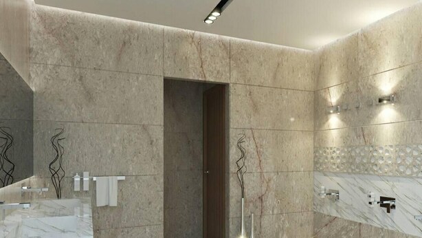 Un baño moderno con paredes de mármol y un espejo grande. Hay dos lavamanos con grifos y un inodoro.
