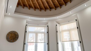 Ein Zimmer mit Holzboden, eingelassener Beleuchtung und großen Fenstern.