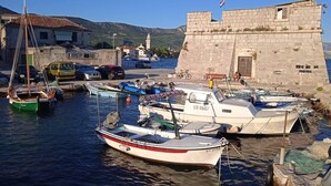Un port où des bateaux sont amarrés près d’un bâtiment historique en pierre.