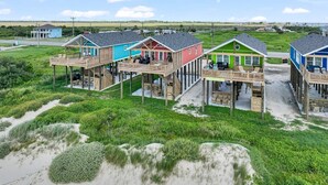 Una propiedad frente al mar con varias edificaciones de madera, con terrazas elevadas y zonas de estar al aire libre.