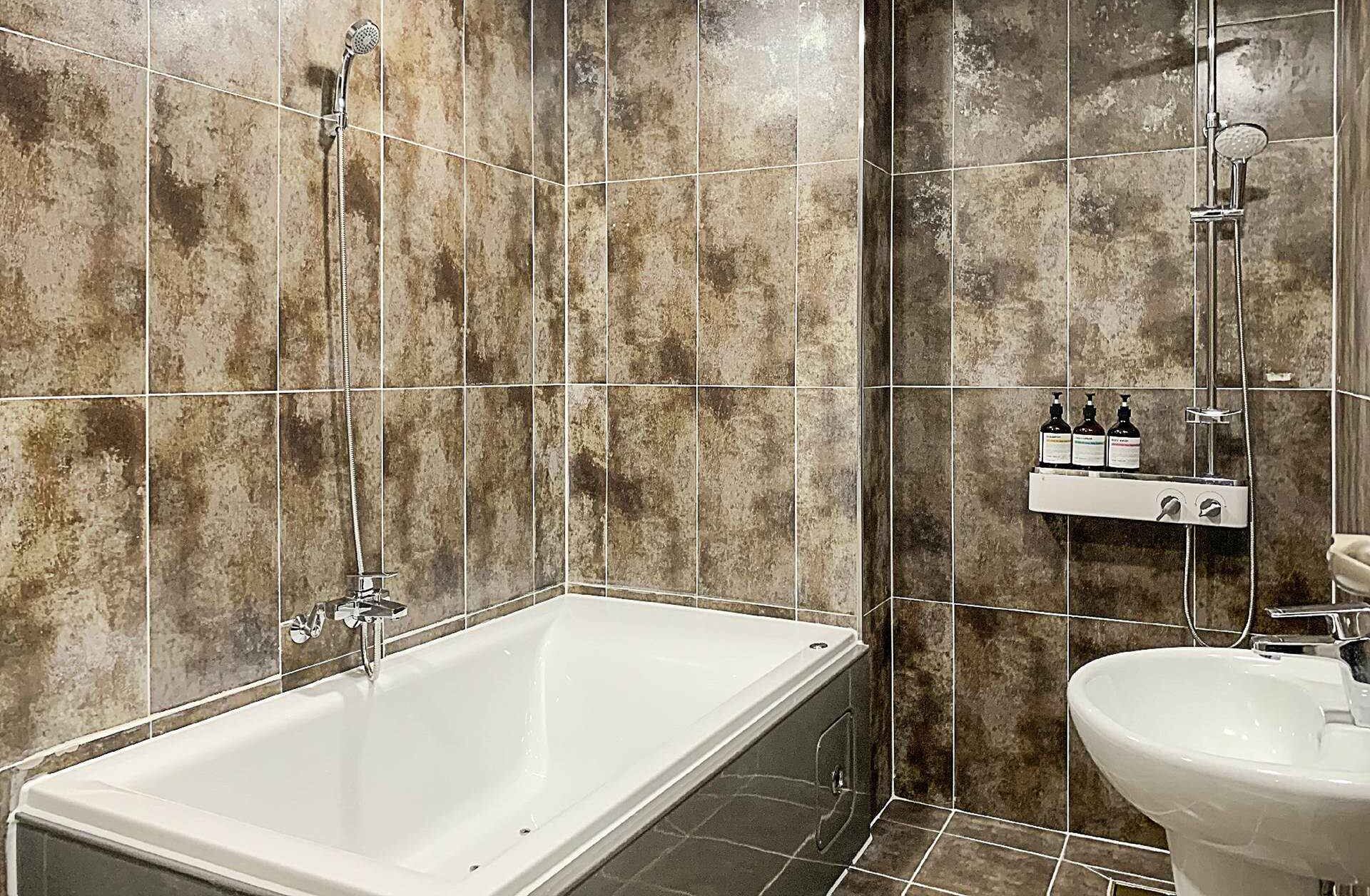A bathroom with a bathtub, a shower, and a sink.