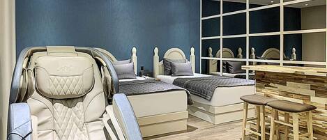 Un dormitorio con una cama, dos mesitas de noche, una silla y un ventanal grande.