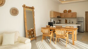 A modern kitchen with wooden cabinets, a built-in island, and a large mirror. - Villa Casa Cielo by OriVista (Canggu)
