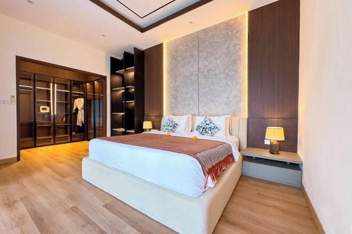 Un dormitorio moderno con una cama grande, estanterías empotradas y un vestidor.