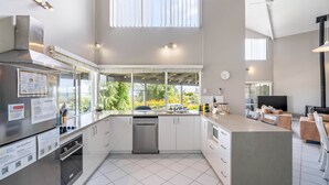 A modern kitchen with a dishwasher, oven, and large windows.