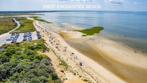 A beach with a parking lot and beachgoers. - Bike trail, Tennis Court, Surrounded by nature (Eastham)