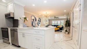 A modern kitchen with white cabinetry, a built-in oven, and a marble backsplash. - King Suite & Patio | Ground Floor | Monthly Stay | 1BR, Pool, Near Tampa | Saddlebrook Resort (Wesley Chapel)