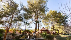 A courtyard with a pool, surrounded by trees and a building with a tiled roof. - Stylish & Comfy ~ 5★ Location, Office, ♛Queen Bed (Ridgecrest)