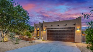 A modern house with a large garage, surrounded by landscaped gardens and trees. - House Rising ☀️ Villa w/ mini-golf, pool and spa (Desert Hot Springs)