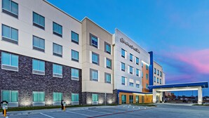 A modern hotel with a flat facade, multiple windows, and a gas station attached. - Hampton Inn & Suites Canyon (Canyon)
