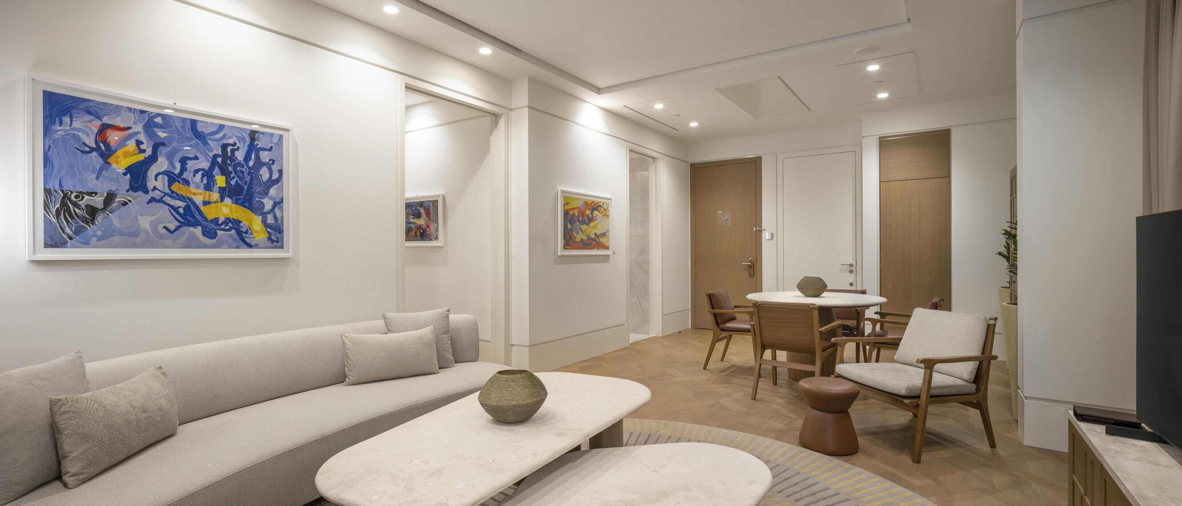 A modern living room with a sofa, coffee table, and dining area.