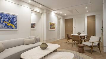 A modern living room with a sofa, coffee table, and dining area.