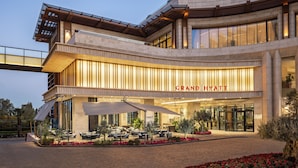 A Grand Hyatt hotel with a modern architectural design, outdoor seating area, and a prominent entrance.