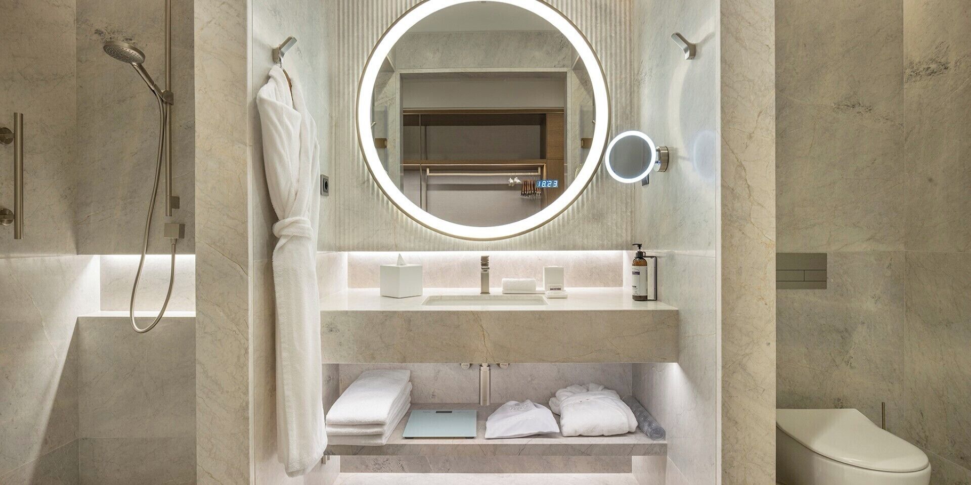 Un baño moderno con ducha integrada, tocador con espejo y retrete.