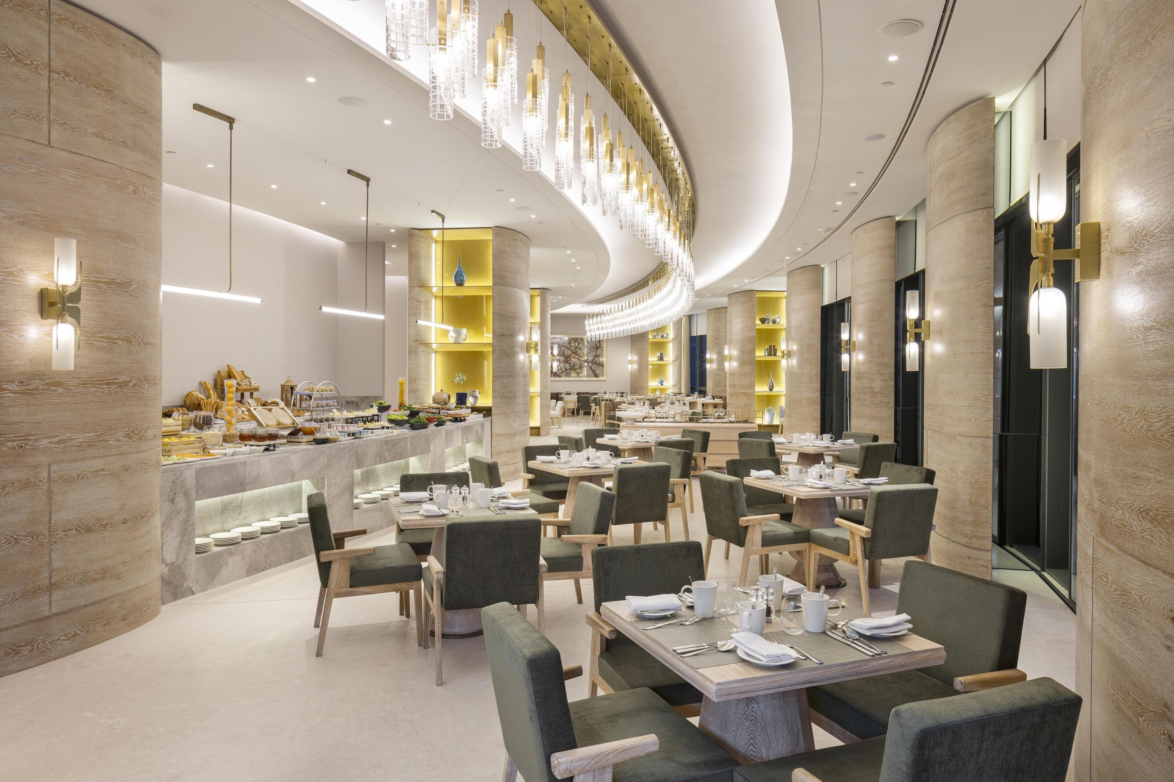 Un ristorante moderno con soffitto curvo, diversi tavoli e sedie.