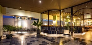 A modern hotel lobby with a checkered floor, a reception desk, and potted plants. - The Sulit Whitefield (Bengaluru)