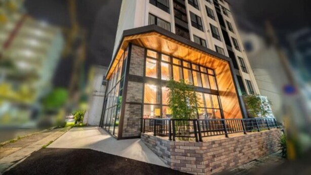 A modern building with a glass facade and a brick base. - Hotel Brick (Naha)