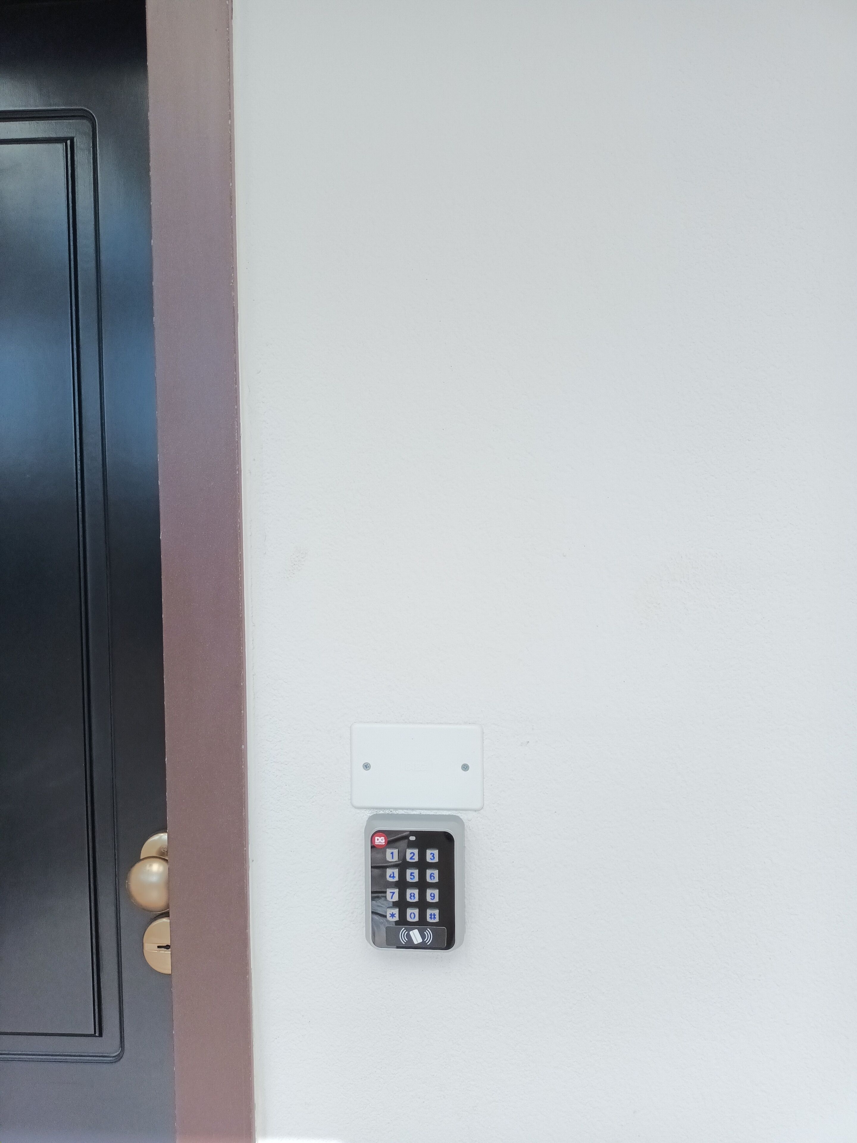 A door with a keypad lock and a wall-mounted control panel.