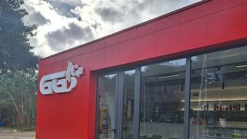 Un edificio rosso con vetrina in vetro e un logo sul lato.