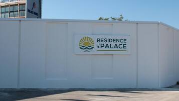 A sign for 'Residence at Palace' with a logo featuring a sun and waves.