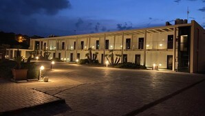 A hotel with a covered outdoor area, multiple windows, and a paved entrance. - Residence al Palace (Vasto)