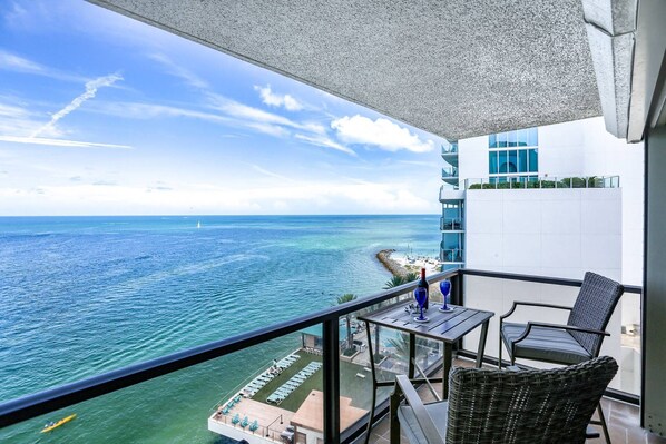 A balcony with a view of the ocean and a beach.