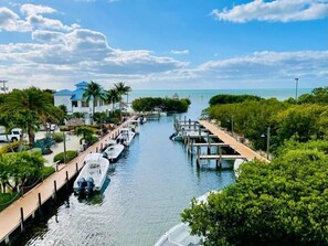 A marina with boats docked, a clear sky, and a view of the ocean. - Ocean View Overlooking Marina Ocean Pointe 5305 (Tavernier)