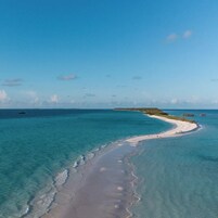 Una playa cerca, arena blanca, traslado desde/hacia la playa, sombrillas
