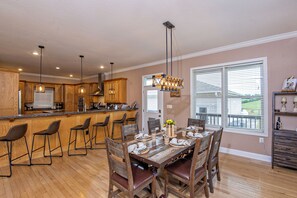 Una cocina amplia con armarios de madera, una barra y una mesa de comedor para seis.