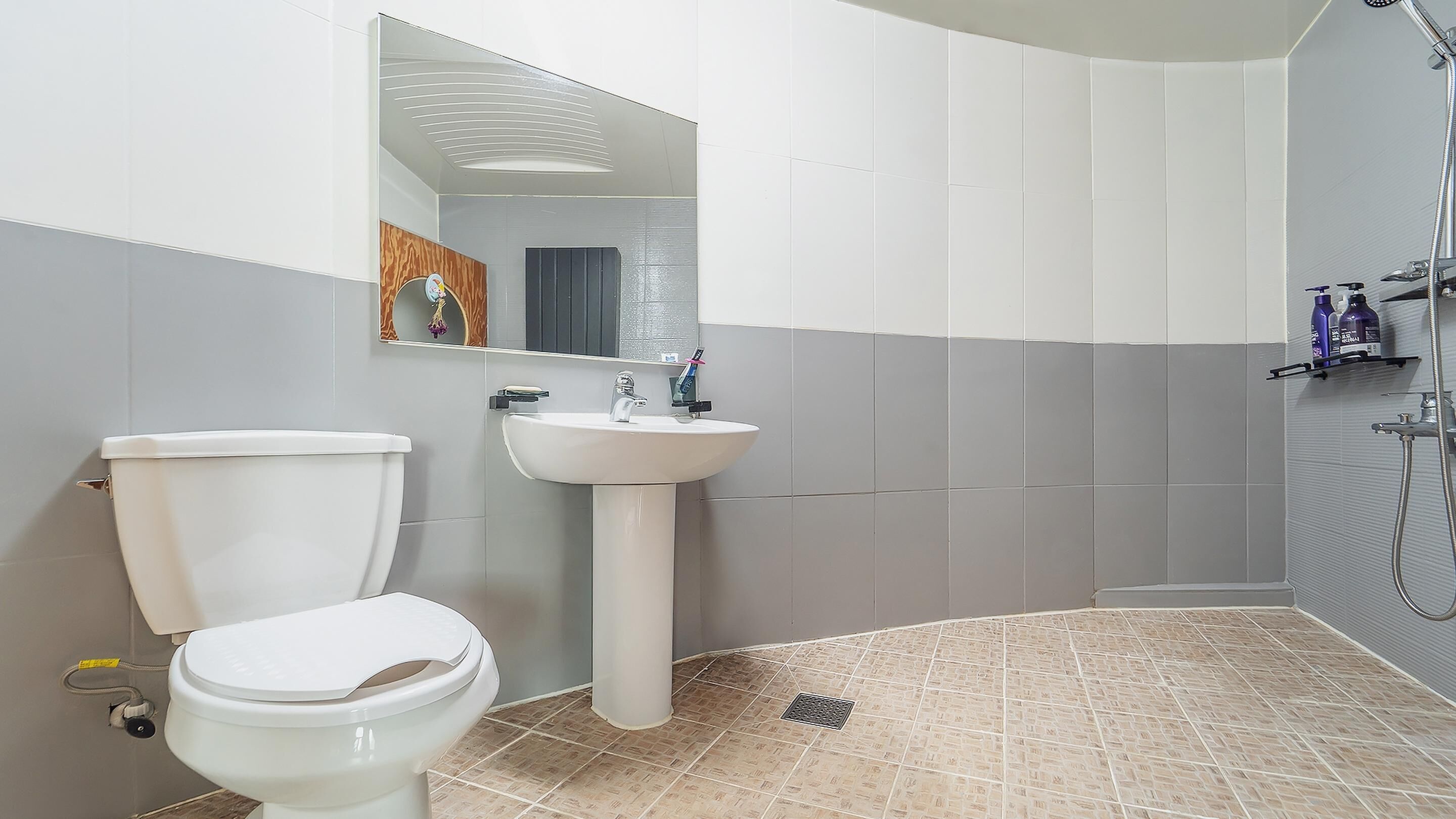 Un baño con inodoro, lavabo y ducha.