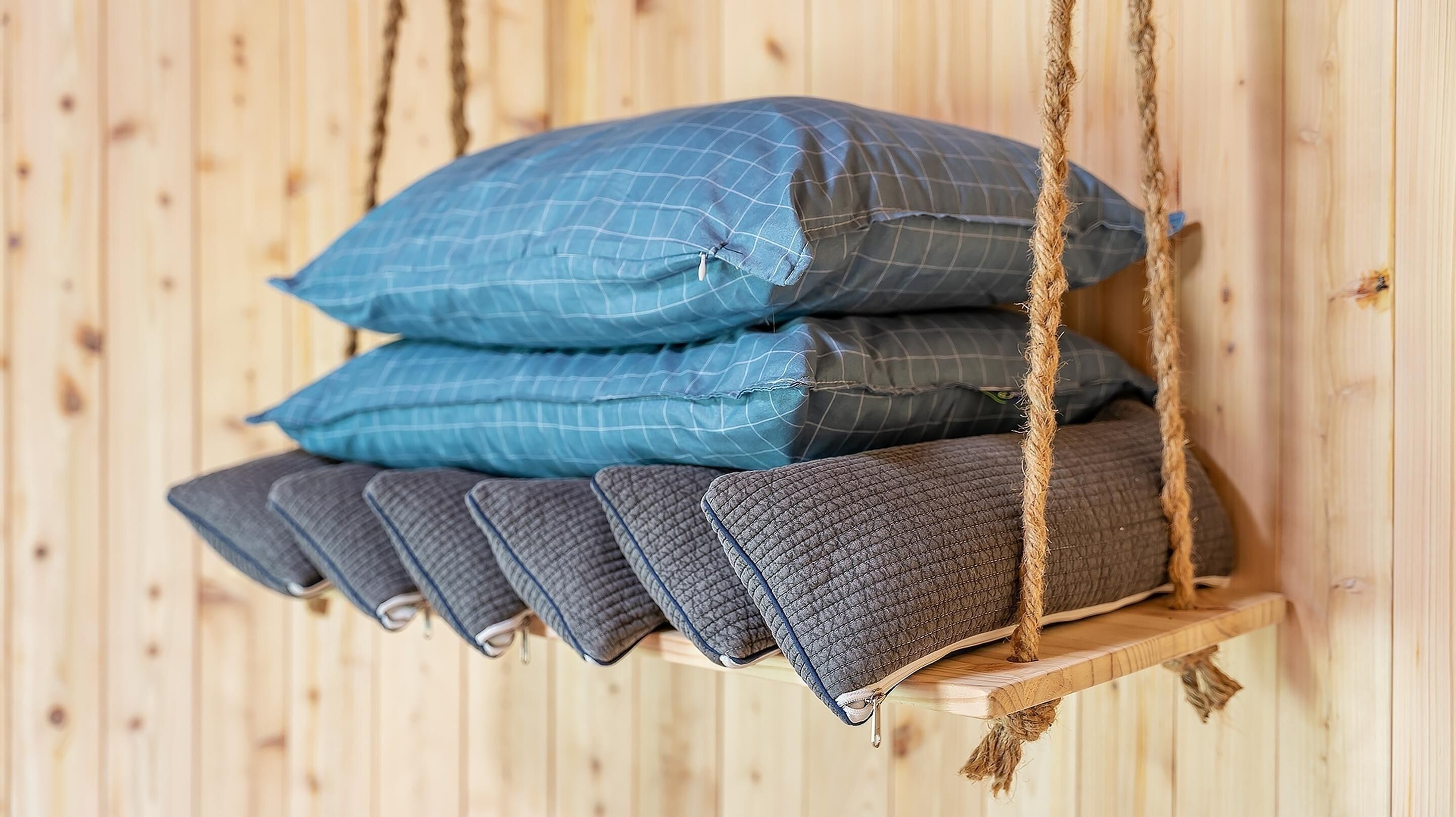 A wooden swing bed with pillows.