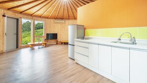 Cuina moderna amb terres de fusta, un rentamànega integrat i una finestra gran amb vista a un paisatge verd.