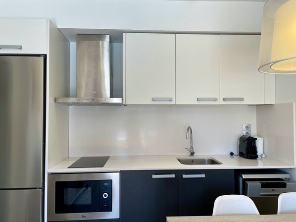A modern kitchen with a stainless steel refrigerator, a built-in microwave, a coffee machine, and a sink. - FESTASTAR 103 (Estartit)