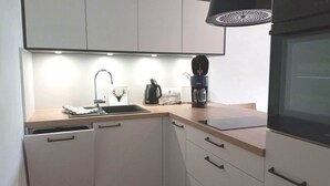 A modern kitchen with a sink, coffee maker, and cabinets. - Fewo "zieglerei", Oberstaufen/steibis (Oberstaufen)