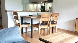 A modern living room with a grey sofa, wooden dining table, and chairs. - Fewo "zieglerei", Oberstaufen/steibis (Oberstaufen)