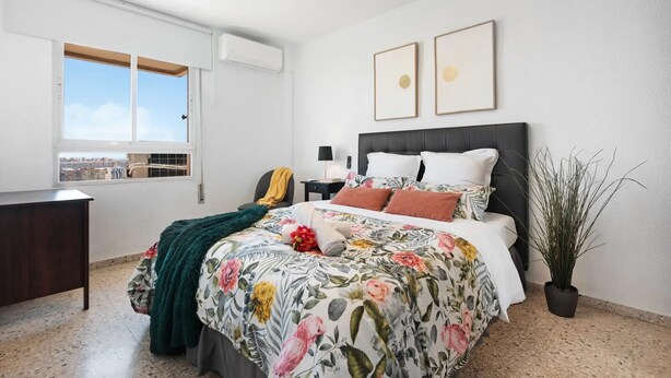 A bedroom with a bed, a desk, a window, and a potted plant. - Casa Angel Malaga (Málaga)