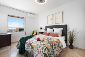 A bedroom with a bed, a desk, a window, and a potted plant. - Casa Angel Malaga (Málaga)